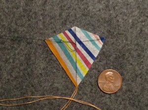 2 inch Sotich Eddy kite, striped cocktail napkin.