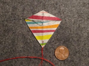 2 inch Sotich Eddy kite, striped cocktail napkin.